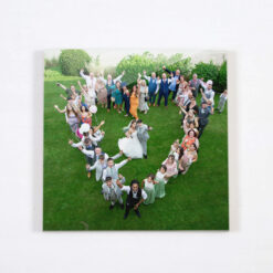 Ceramic tile with photo of a wedding group in a heart shape, photographer shooting from above.